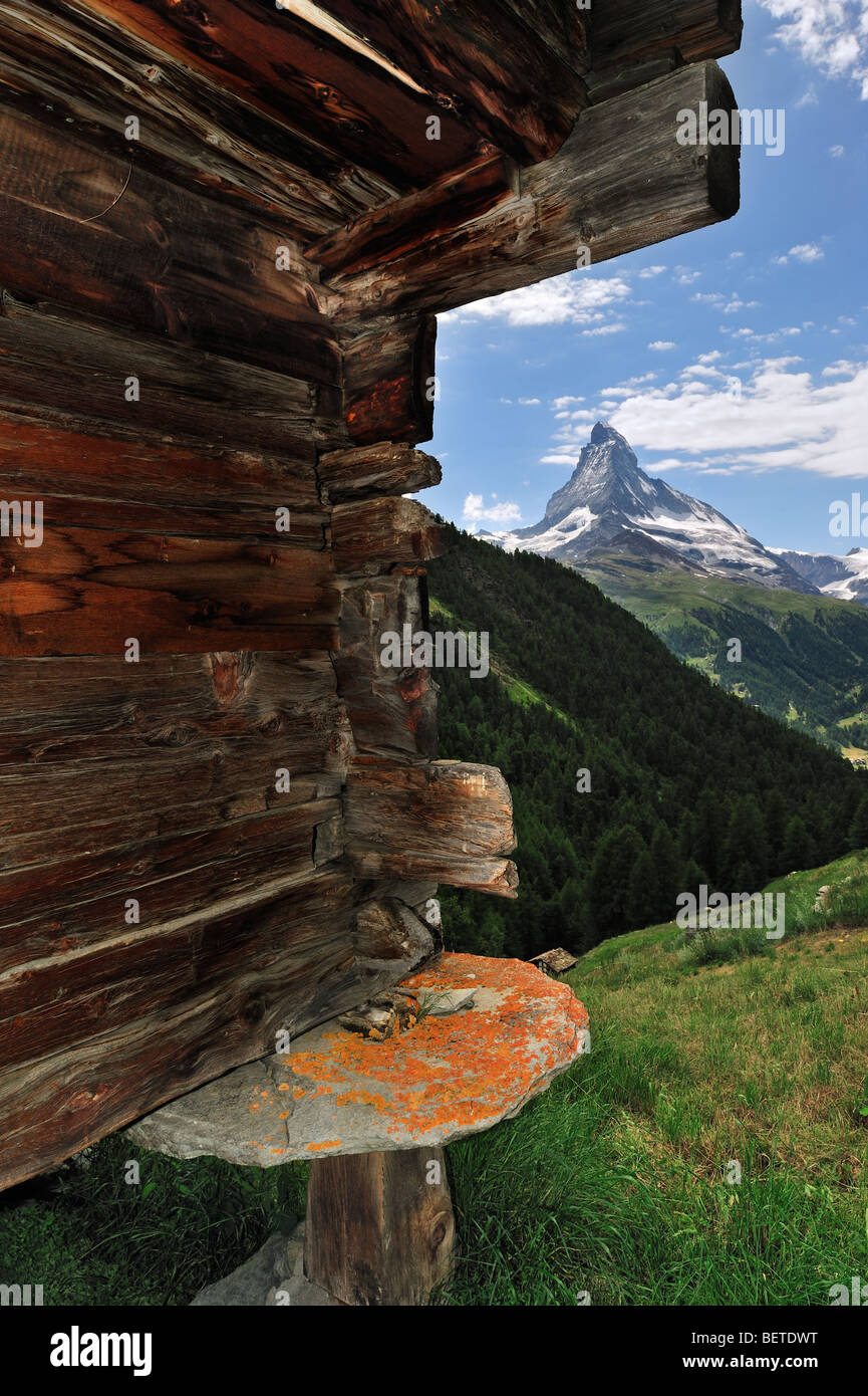 Matterhorn und hölzerne Getreidespeicher / Raccard zeigen runde Steinplatte um zu verhindern, dass Nagetiere in, Wallis, Alpen, Schweiz Stockfoto