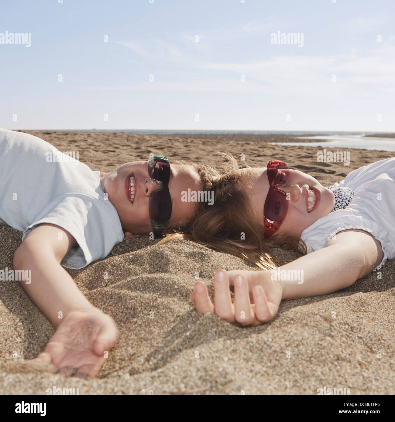 Kinder mit einer Sonnenbrille, die Verlegung auf sand Stockfoto