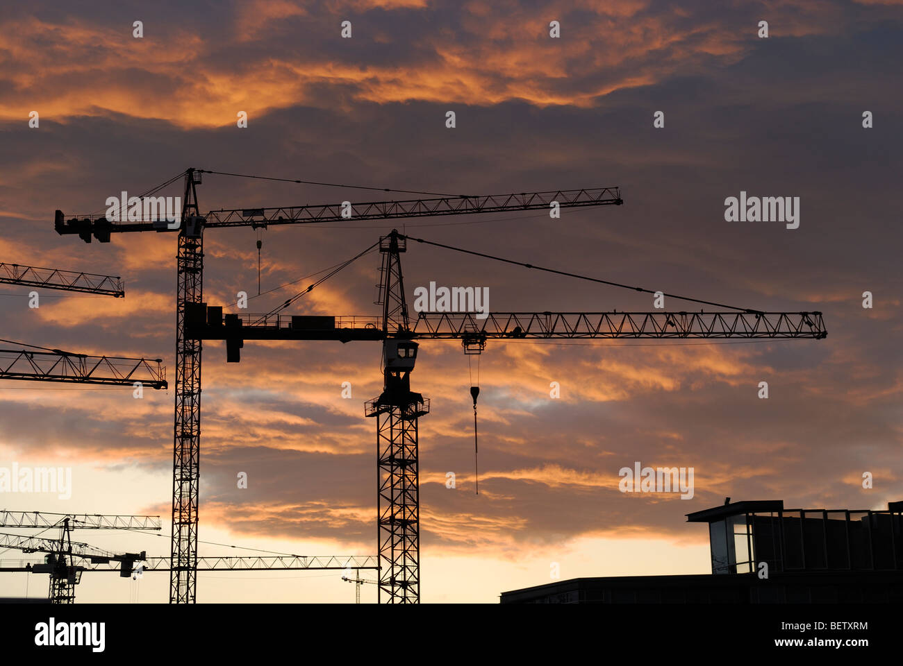 Bau-Turmdrehkrane Silhouette gegen Abendrot Stockfoto