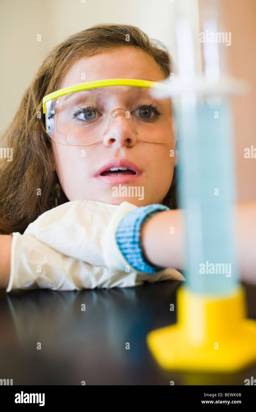 Student auf der Suche in einem Messzylinder in einem Labor Stockfoto