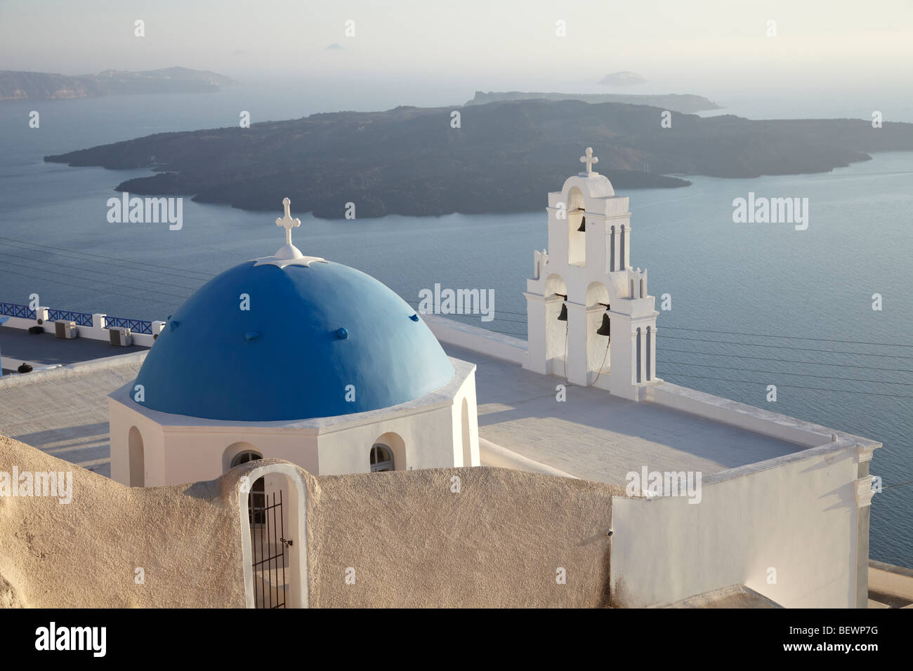 Griechische weiße Kirche mit Glockenturm und blauen Kuppel, mit Blick auf das Meer, Santorini, Kykladen, Griechenland. Stockfoto