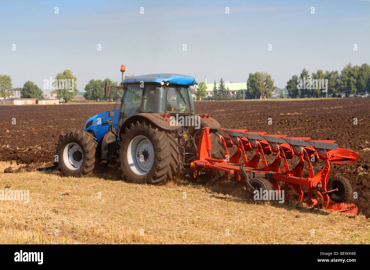 Landwirtschaft-Traktor mit Pflug im Feld Stockfoto