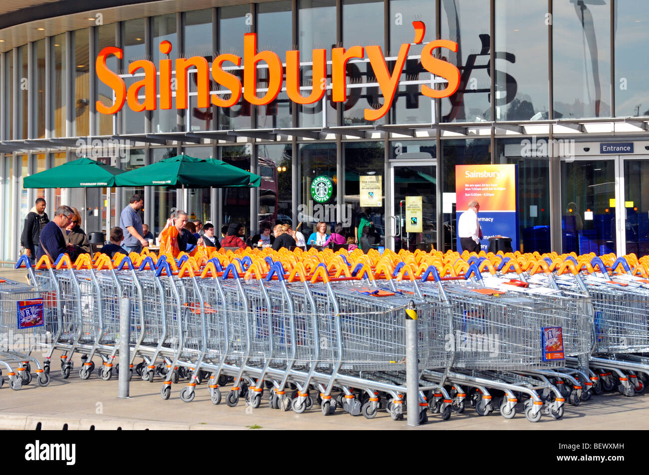 Sainsburys Supermarkt Business Retail Shop vor Trolley Cart Park und Store Eingang mit Starbucks Coffee Shop Greenwich London England UK Stockfoto