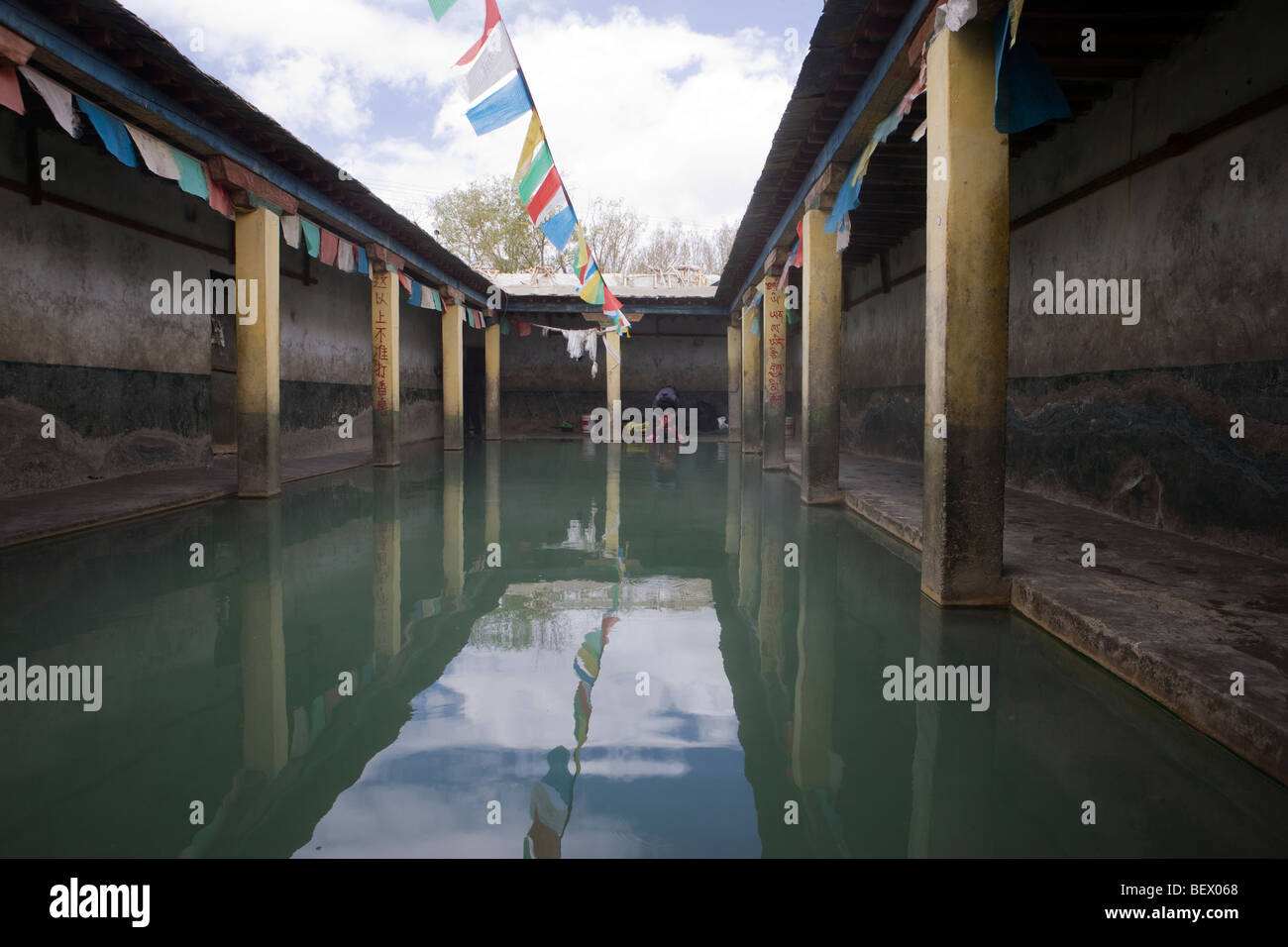 Drigung Hot Springs in Tibet, eine heilige Stätte in der Nähe des Klosters Tidrum mit heilenden Wasser, Gebetsfahnen und klösterlicher Architektur in einem hoch gelegenen Tal Stockfoto