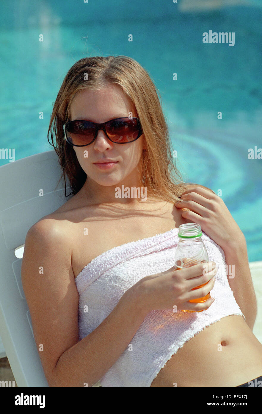 schöne Frau mit Sonnenbrille vor Wasserbecken liegenden Stockfoto