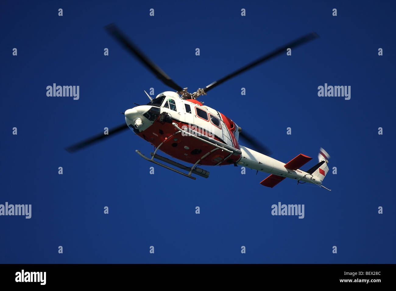 Fliegenden Hubschrauber im tiefblauen Himmel. Coast Guard Farben. Stockfoto