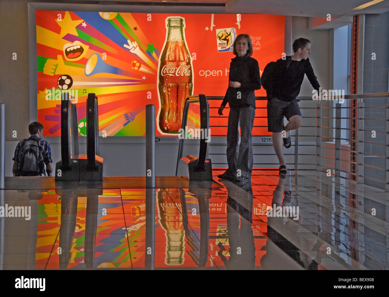 Frau und junger Mann entspannend vor 2010 Fussball Anzeige in Oliver Tambo International Airport, Johannesburg, Südafrika Stockfoto