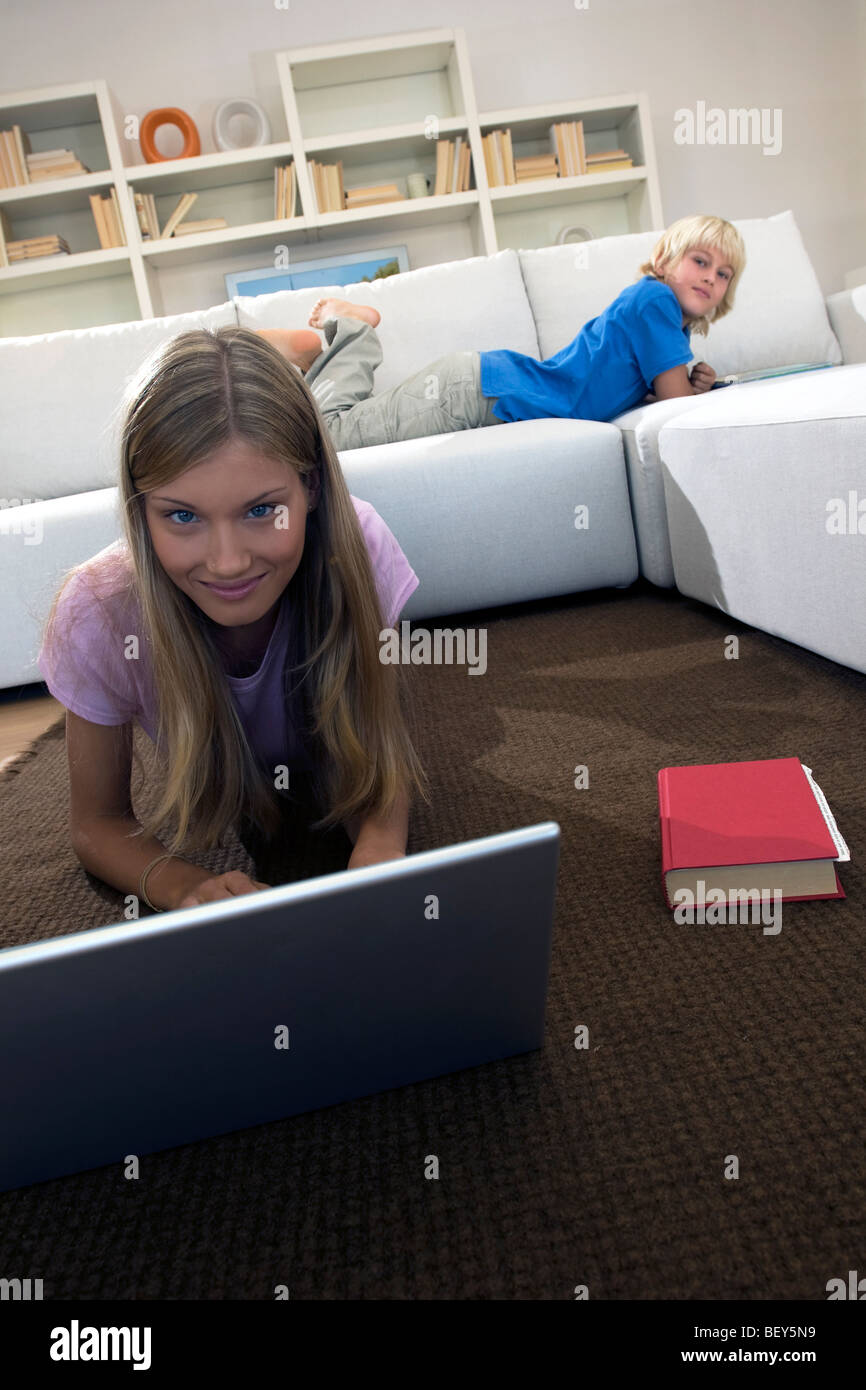 Bruder und Schwester im Wohnzimmer, Mädchen mit laptop Stockfoto