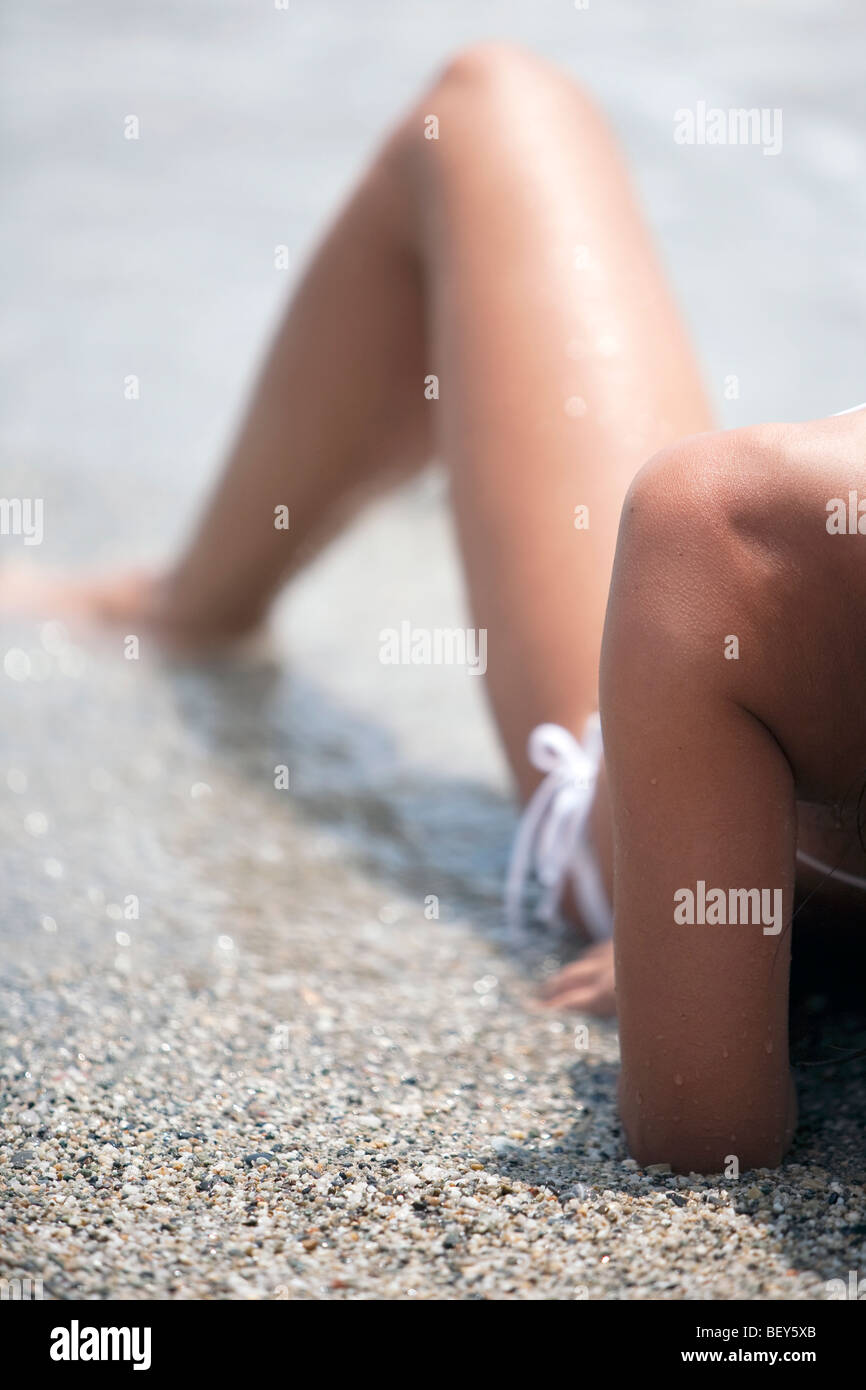 junge Frau sitzt am Ufer des Meeres Stockfoto