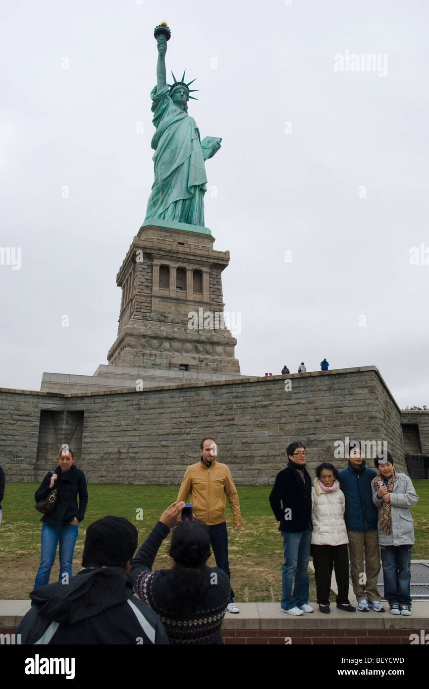 Touristen posieren für Fotos vor der Statue of Liberty, New York City Stockfoto