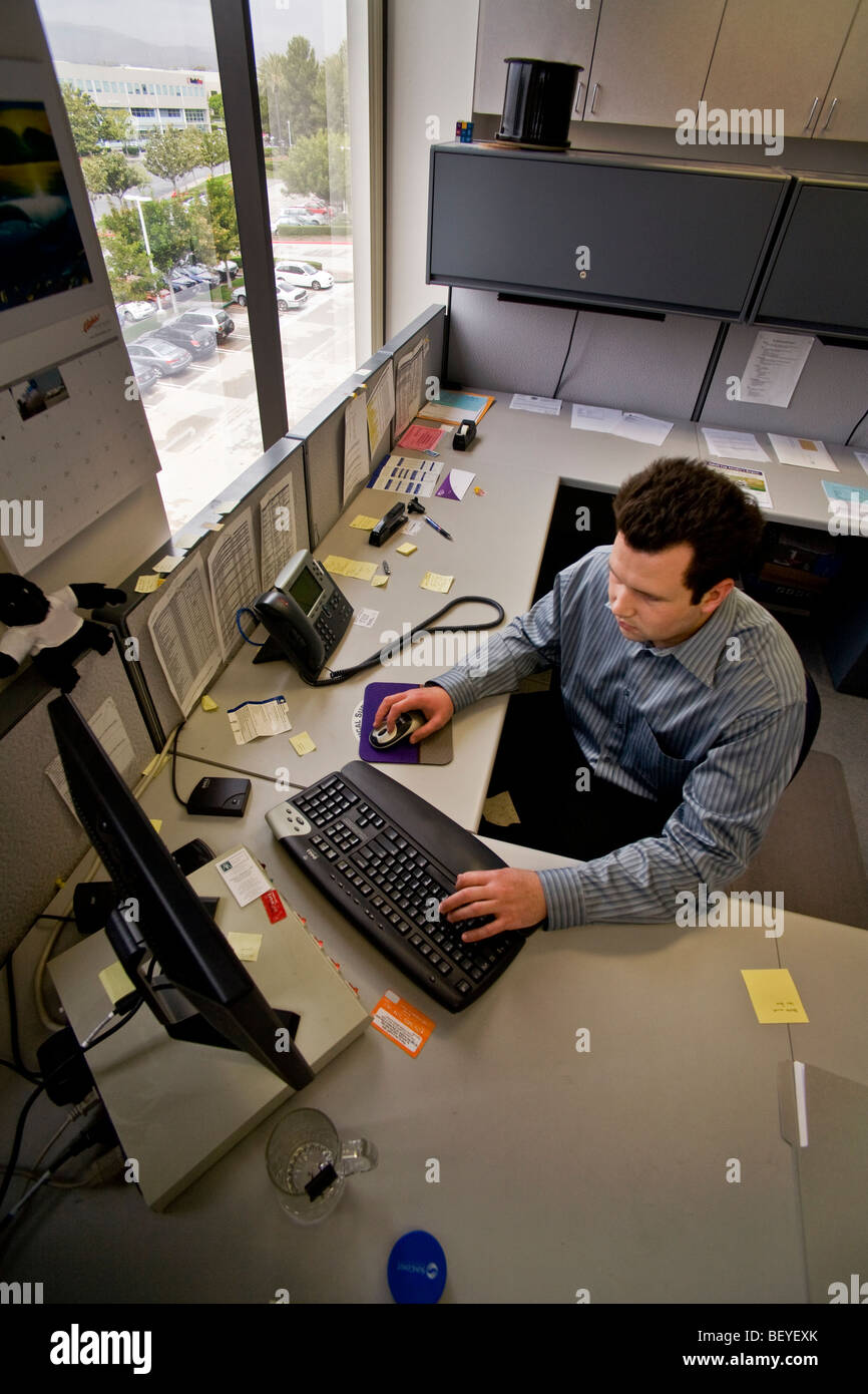 Bei eine Finanzberatung Irvine, Kalifornien arbeitet finanzielle Forscher an seinem Arbeitsplatzcomputer. Stockfoto