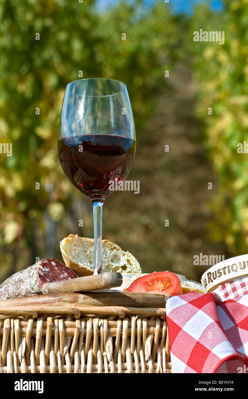 Picknick mit Rotwein Brot Käse und saucisson auf rustikalen Picknick Korb im französischen Weinberge Frankreich Stockfoto