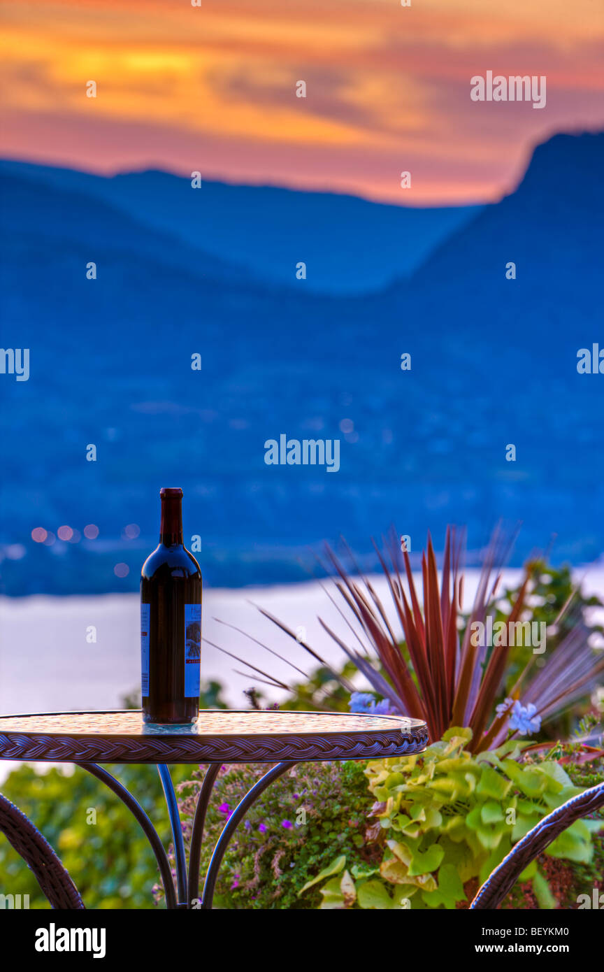 Flasche Wein auf einer Terrassentisch Lang Vineyards, Naramata während des Sonnenuntergangs über Okanagan Lake, Okanagan-Similkameen Region, Okana Stockfoto
