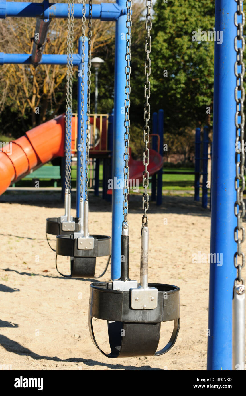 eine Reihe von leeren Schaukeln auf einer Grundschule Spielplatz Stockfoto