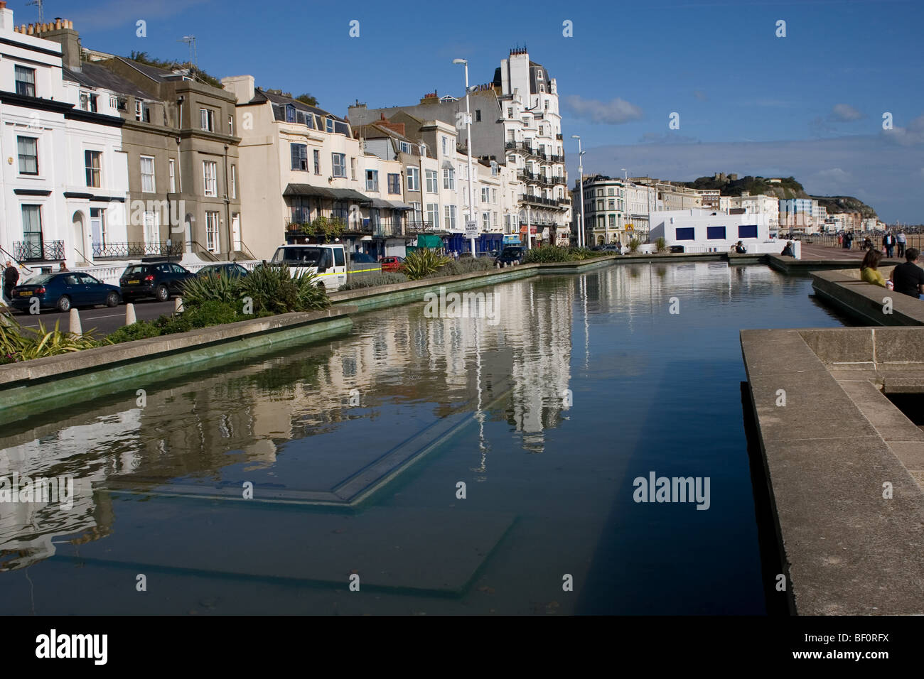 Hastings Meer Straße zeigen Hotels und Gebäude spiegelt sich in einem Zierteich. Stockfoto