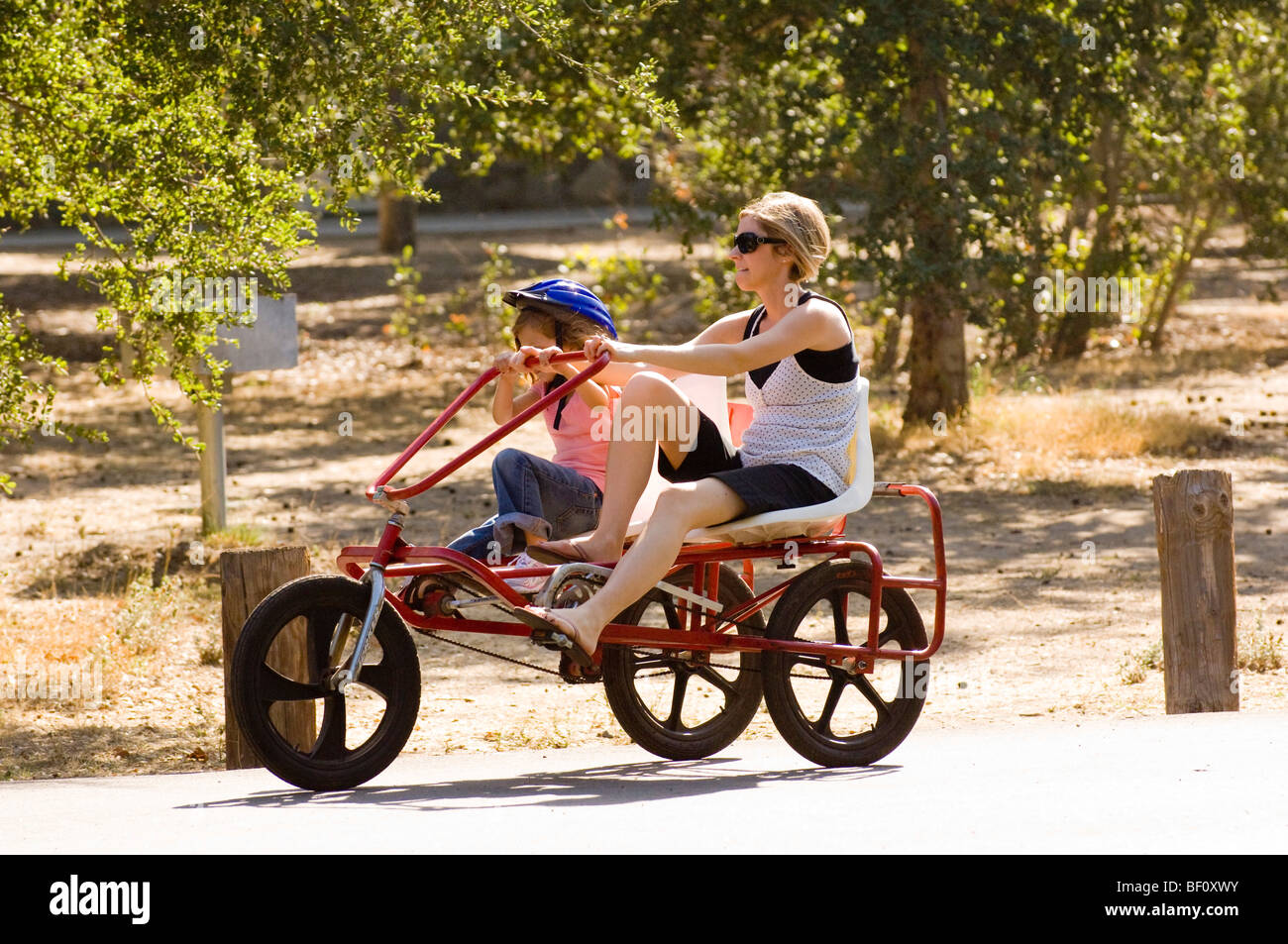 Eine Frau und Tochter Fahrrad Zweipersonen-um Irvine Regional Park in Orange, Kalifornien in der Nähe von the Orange County Zoo. Stockfoto