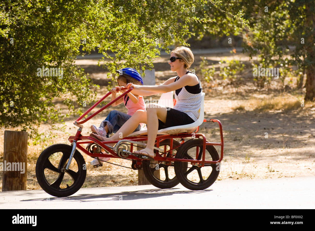 Eine Frau und Tochter Fahrrad Zweipersonen-um Irvine Regional Park in Orange, Kalifornien in der Nähe von the Orange County Zoo. Stockfoto
