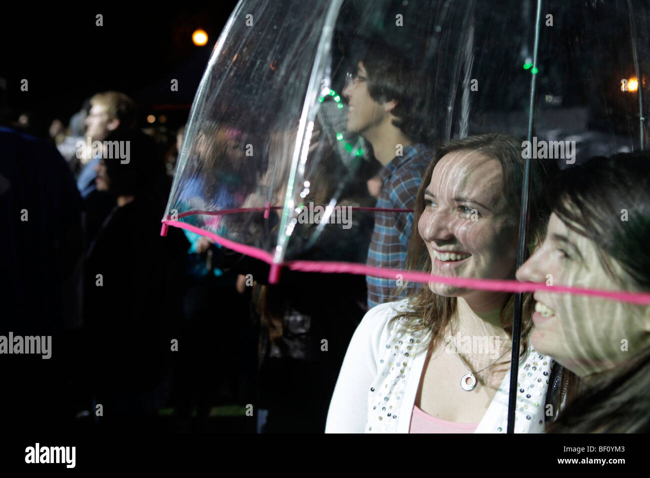 Zwei Frauen stehen unter und Regenschirm in des Victorias Secret Pink Konzert an der Indiana University. Stockfoto