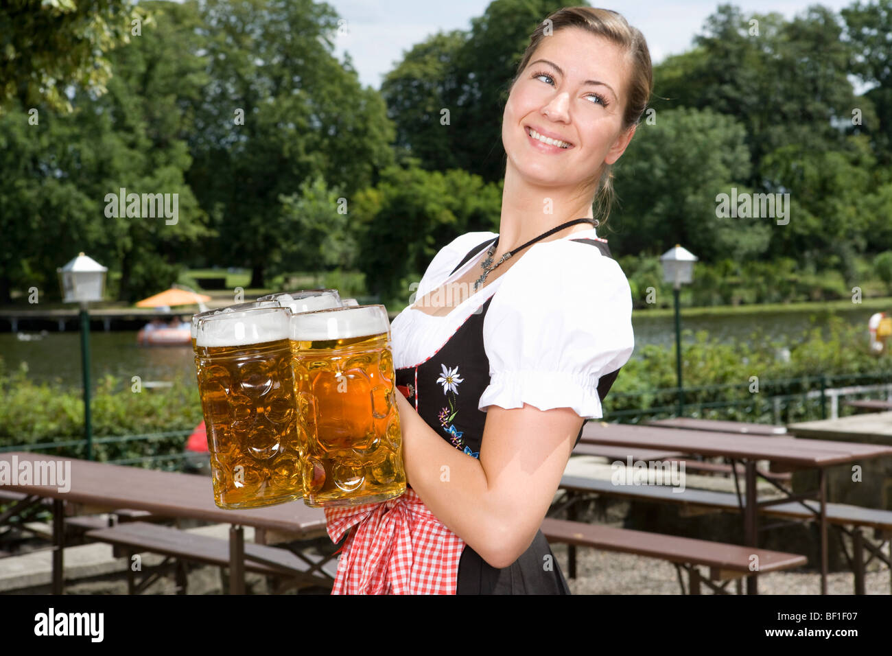 Ein traditionell bekleidet deutsche Frau, Bier in einem Biergarten Stockfoto