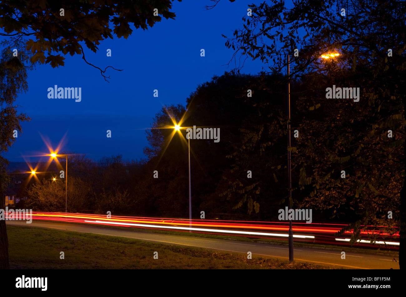 Verkehr-Trails auf einer Landstraße in der Abenddämmerung Stockfoto