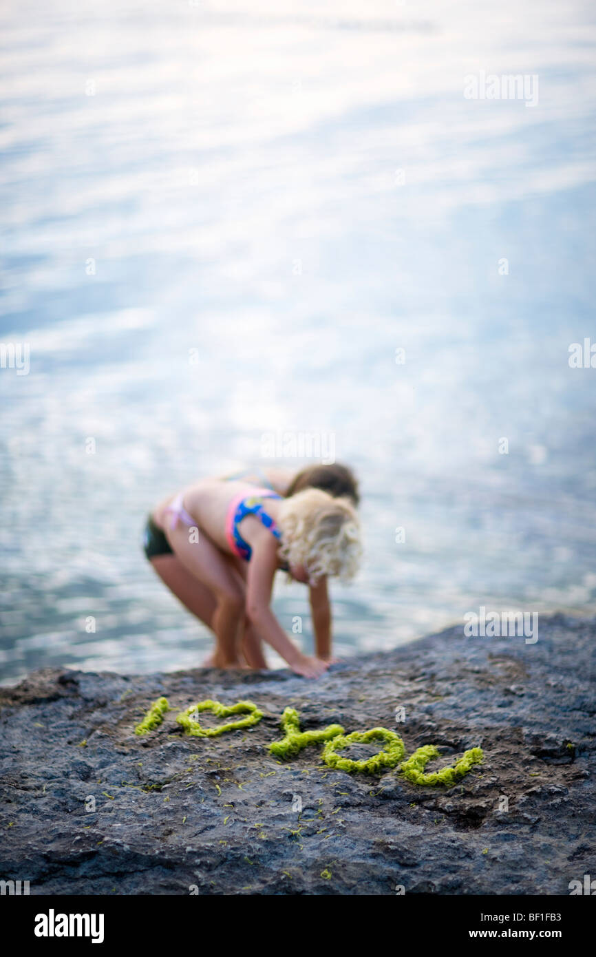 Mädchen spielen am Wasser, Schweden. Stockfoto