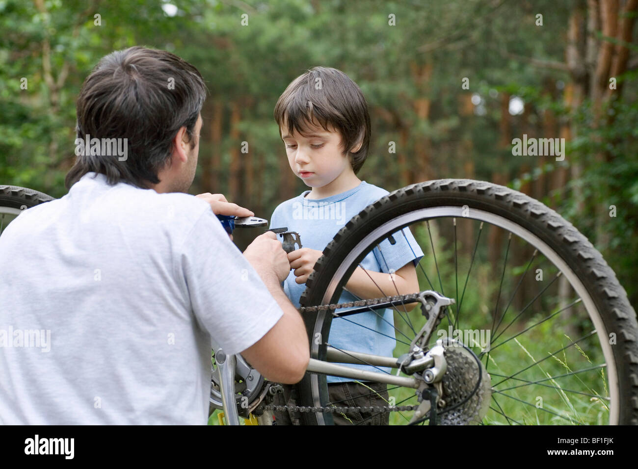 Vater und Sohn gemeinsam ein Fahrrad reparieren Stockfoto
