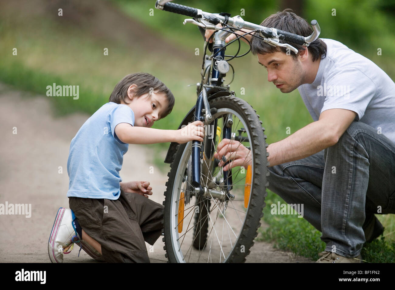 Vater und Sohn ein Fahrrad reparieren Stockfoto