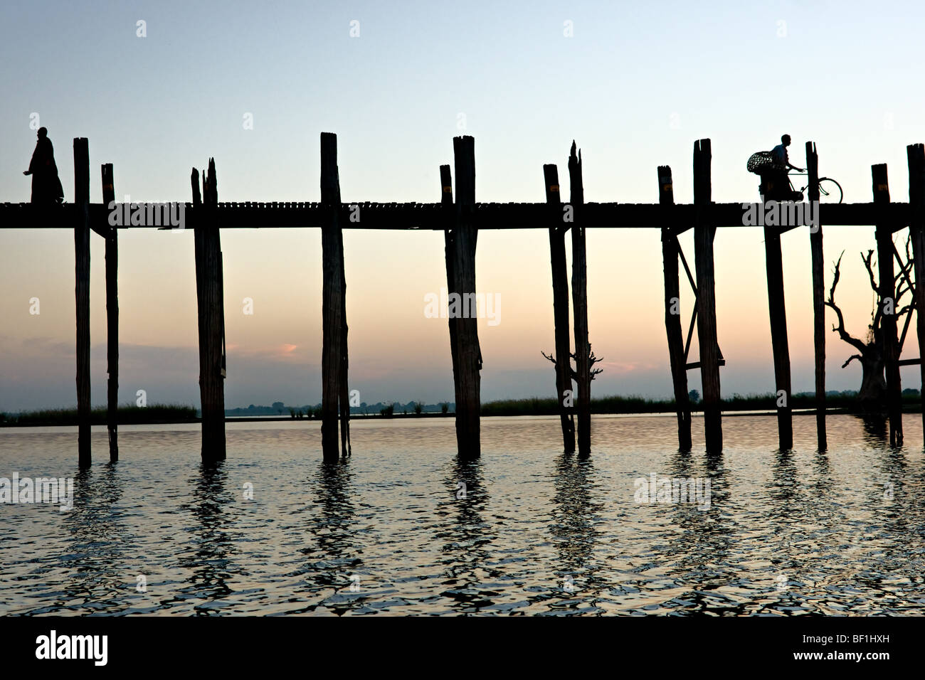 Passanten in Amarapura Brücke bei Sonnenuntergang, Mandalay, Myanmar. Stockfoto