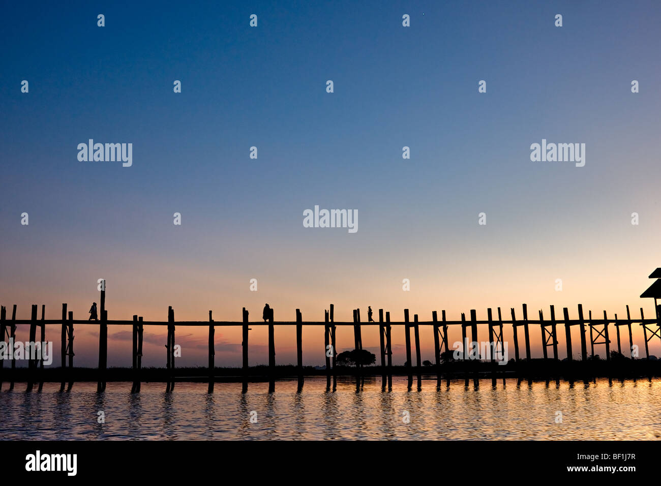 Passanten in Amarapura Brücke bei Sonnenuntergang, Mandalay, Myanmar. Stockfoto