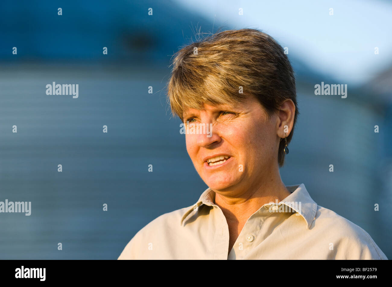 Landwirtschaft - Porträt von einer Bäuerin im Feld mit Getreide-Behälter im Hintergrund unscharf / Minnesota, USA. Stockfoto