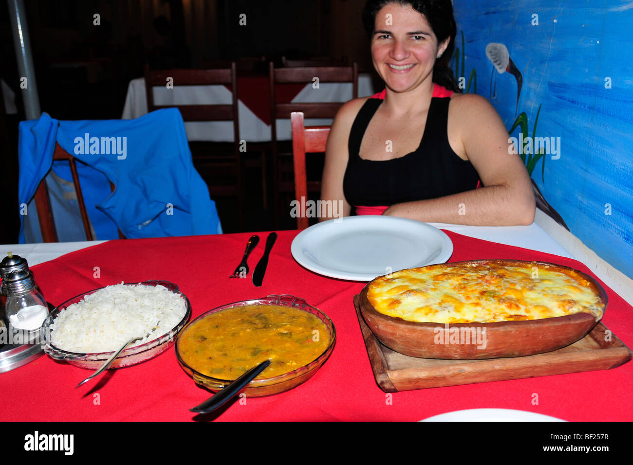 Brasilianische Frau mit typischen Speisen aus Pantanal; Hauptgericht Fleisch von Zuchtwild Alligator, Bonito, Mato Grosso do Sul Stockfoto