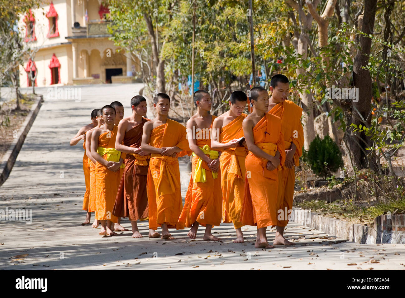 Buddhistische Mönche gehen auf der Straße vor dem Kloster MwSt Pa Phonphao, Luang Prabang, Laos Stockfoto