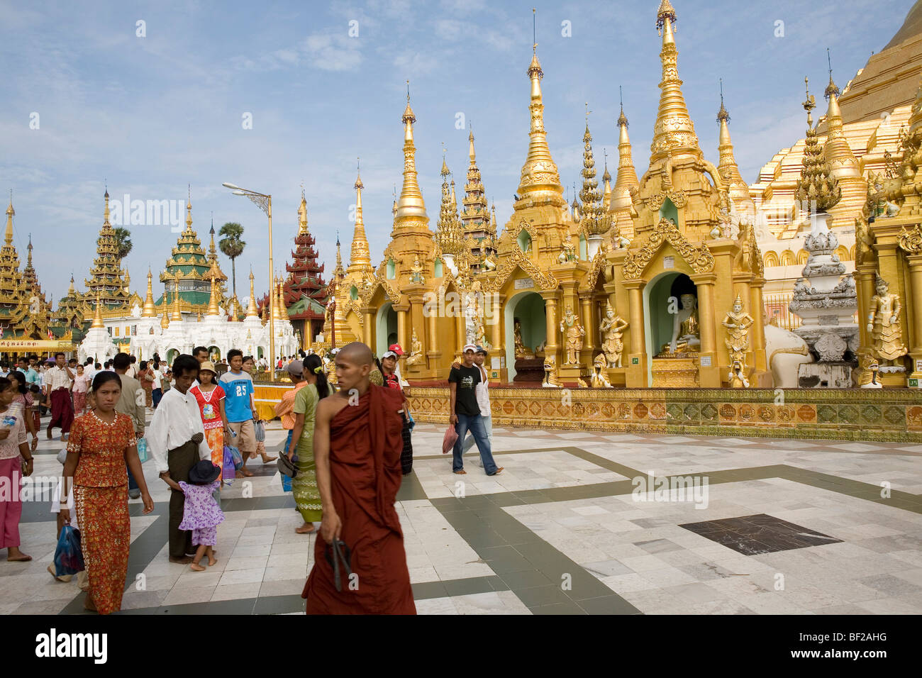 Buddhistischen Mönch und Touristen vor goldenen Stupas auf dem Gelände der Shwedagon-Pagode in Yangon, Rangun, Myanmar, Birma Stockfoto