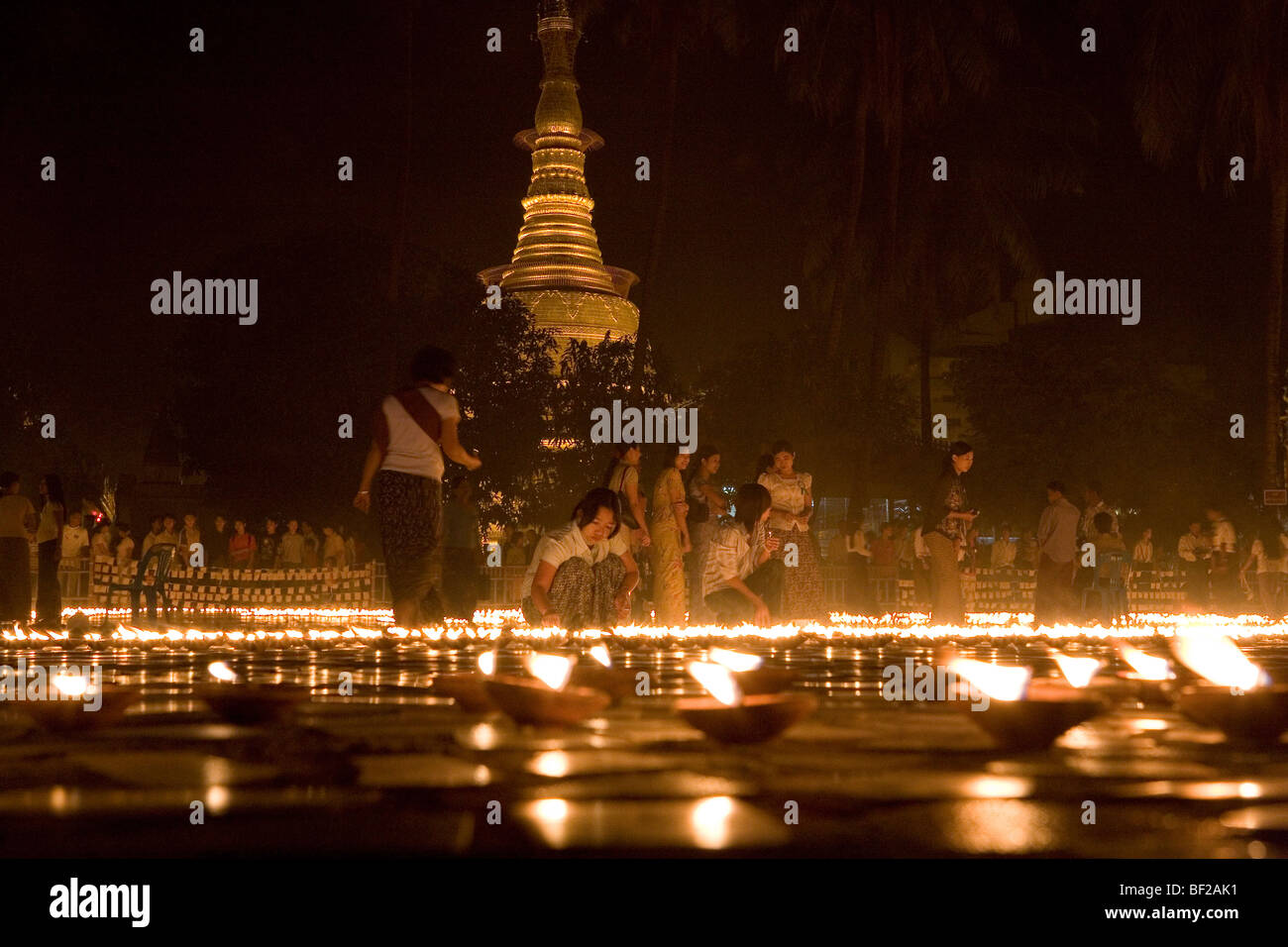 Buddhistische Gläubige, die Kerzen in der Botataung-Pagode bei Nacht, Yangon, Rangun, Myanmar, Burma Stockfoto