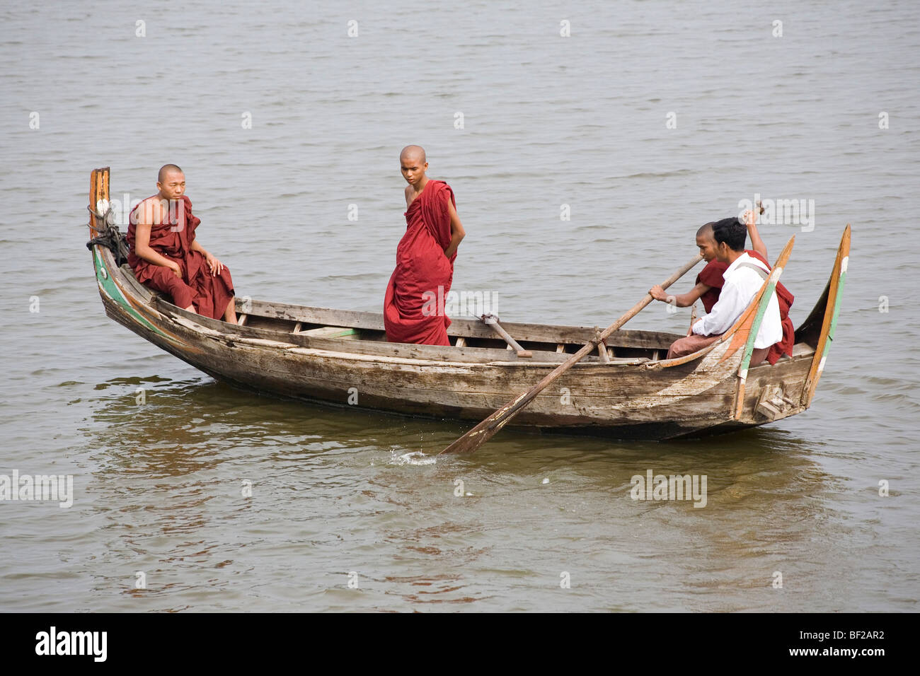 Buddhistische Mönche in einem Ruderboot auf Taungthaman See in Amarapura in der Nähe von Mandalay, Birma, Myanmar Stockfoto