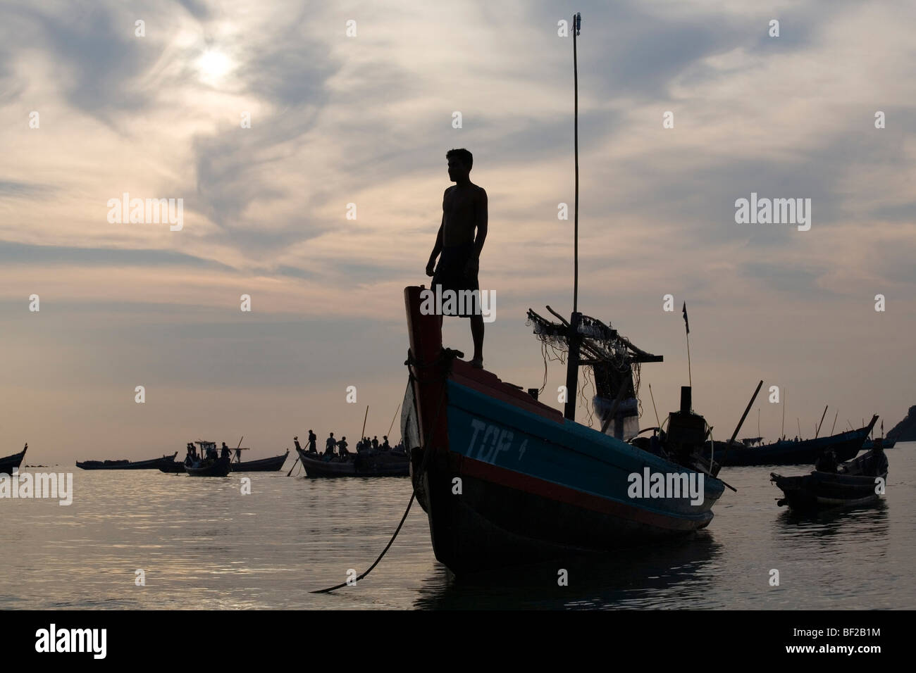 Mann auf einem Fischerboot in den Sonnenuntergang in Ngapali Beach, Golf von Bengalen, Rakhine State in Myanmar Burma Stockfoto