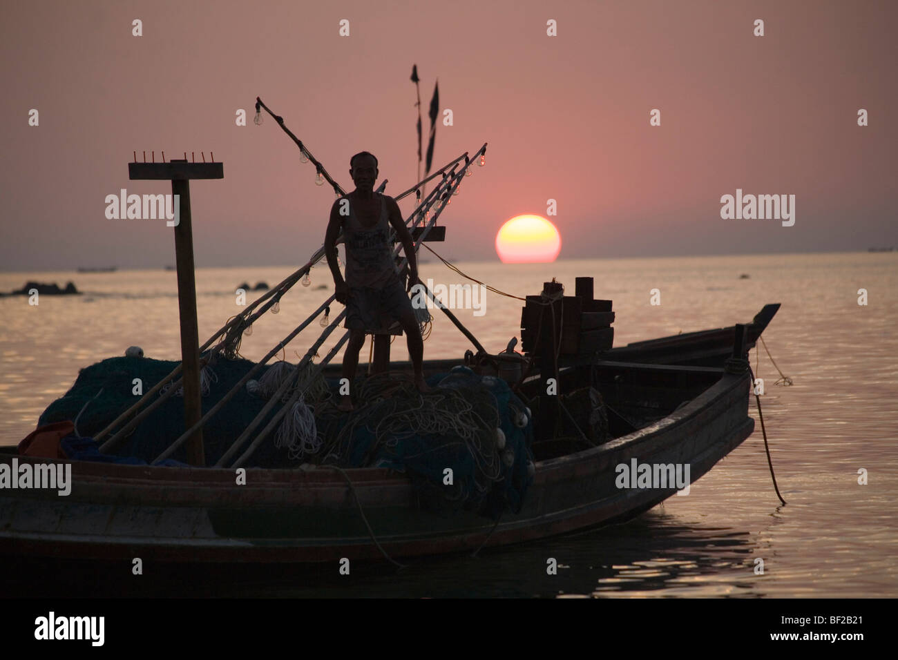 Mann auf einem Fischerboot bei Sonnenuntergang in Ngapali Beach, Golf von Bengalen, Rakhine State in Myanmar Burma Stockfoto