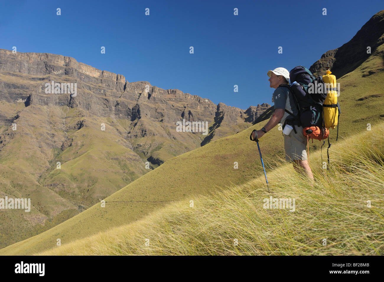 Männlichen kaukasischen Wanderer mit Blick in Richtung Gebirge, Drakensberg Nationalpark Ukuhlamba, Kwazulu Natal, Südafrika Stockfoto