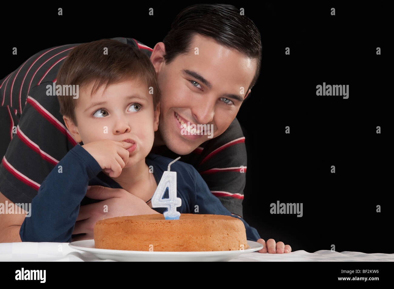 Porträt eines Mannes mit seinem Sohn hinter einer Geburtstagstorte Stockfoto