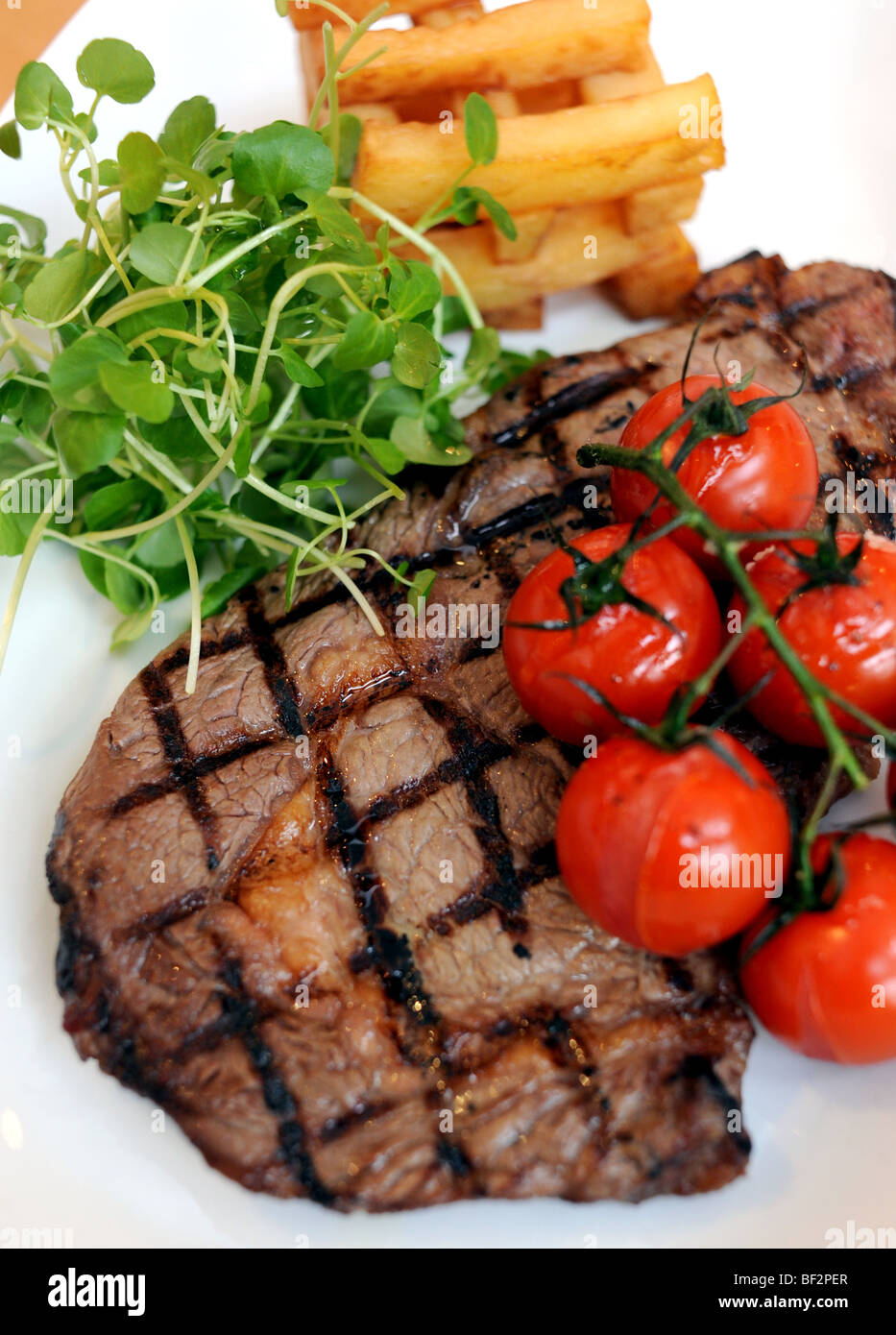 Freilandhaltung aufgezogen Beef Rib Eye Steak mit Strauchtomaten, serviert in der Galerie Bistro in Hove UK Stockfoto