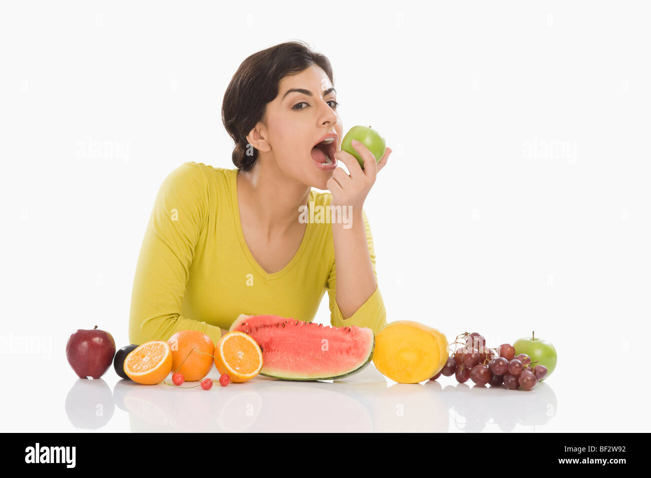 Porträt einer Frau, die einen grünen Apfel zu essen Stockfoto