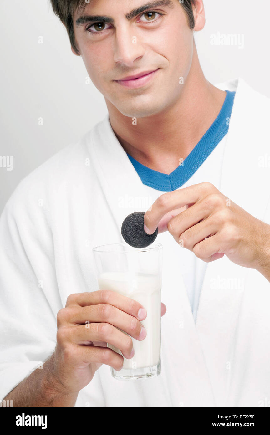 Porträt eines Mannes, einen Cookie in ein Glas Milch Eintunken Stockfoto