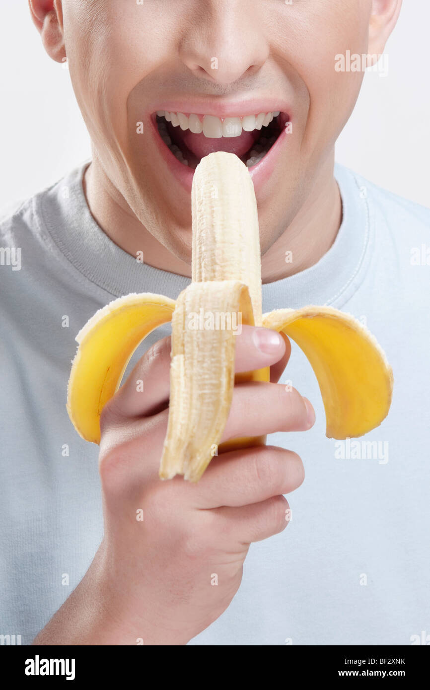 Nahaufnahme eines Mannes eine Banane essen Stockfoto