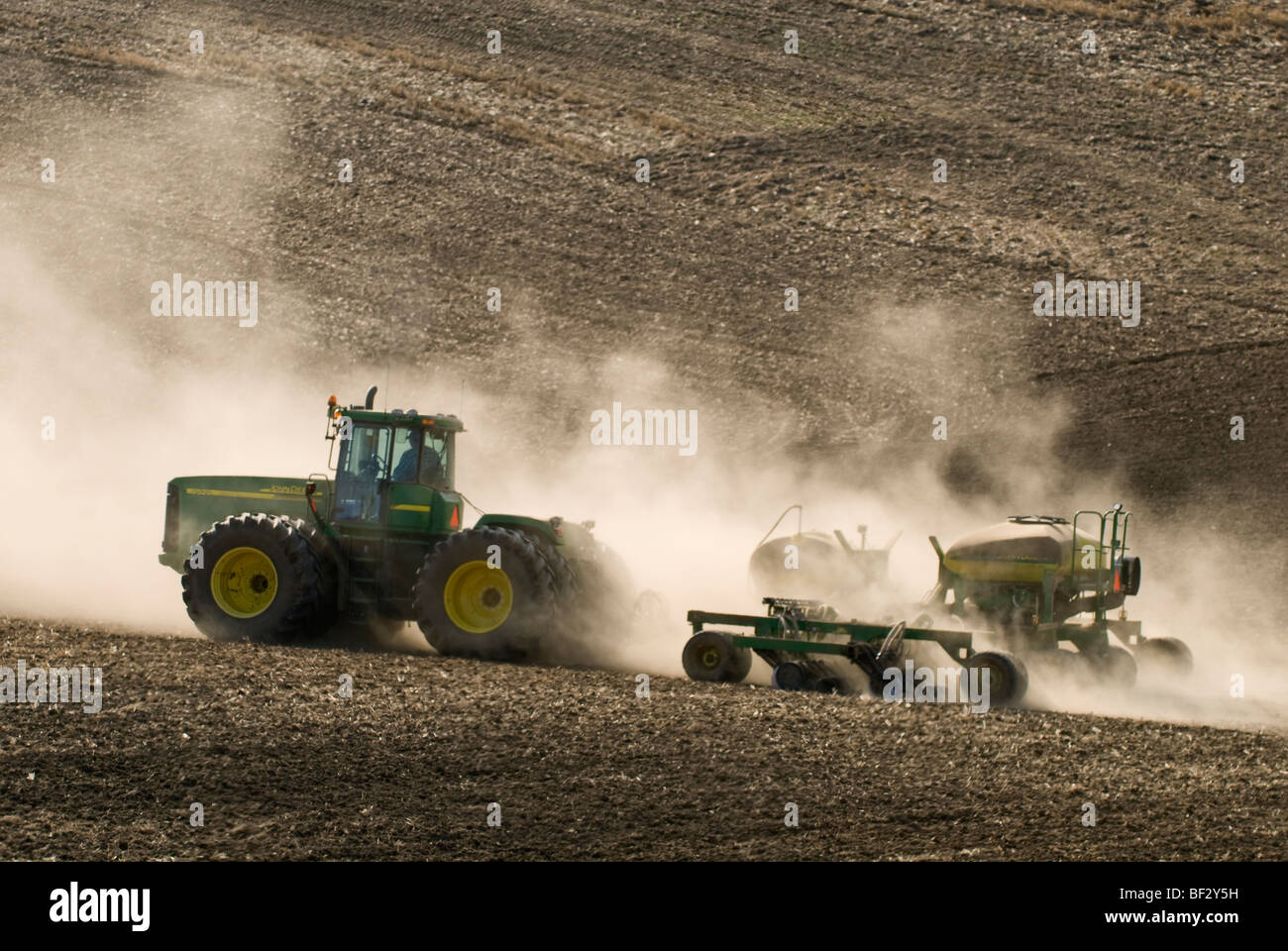 Ein John Deere Traktor und Luft Sämaschine Pflanzung Garbanzo Bohnen (Kichererbsen) in den sanften Hügeln der Palouse / Washington, USA. Stockfoto