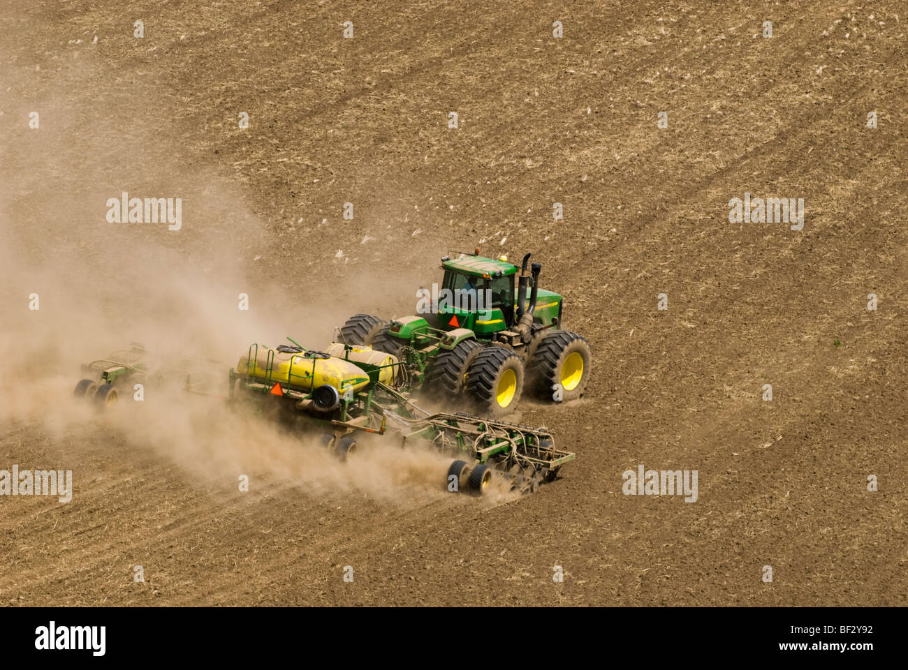 Ein John Deere Traktor und Luft Sämaschine Pflanzung Garbanzo Bohnen (Kichererbsen) in den sanften Hügeln der Palouse / Washington, USA. Stockfoto