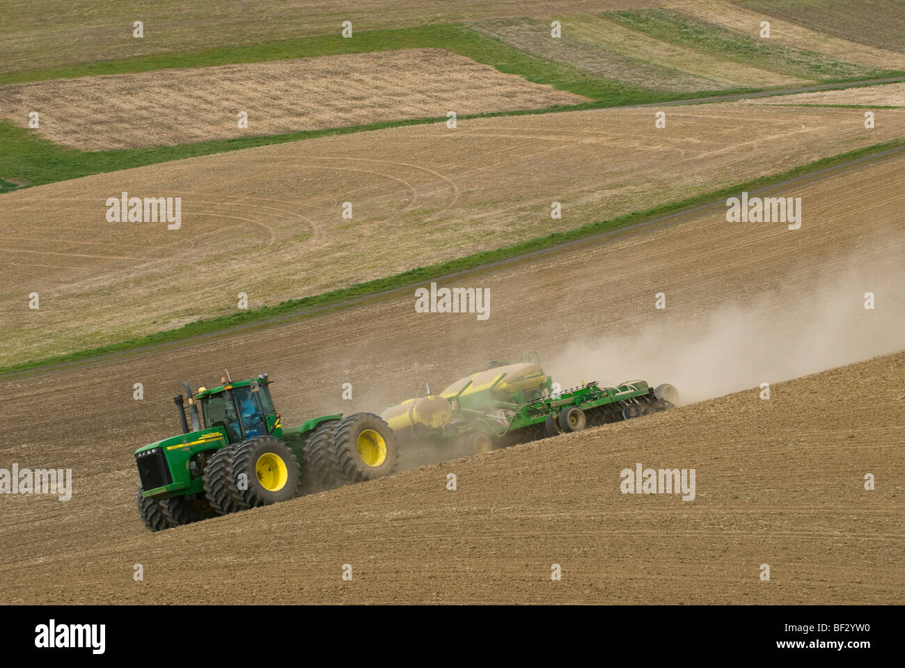 Ein John Deere Traktor und Luft Sämaschine Pflanzung Garbanzo Bohnen (Kichererbsen) in den sanften Hügeln der Palouse / Washington, USA. Stockfoto