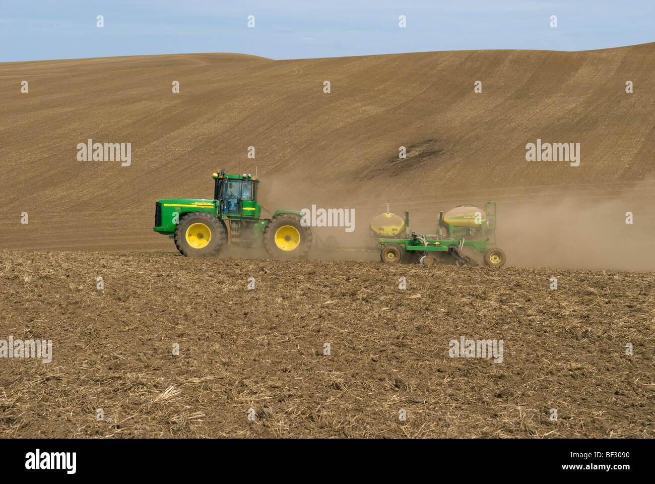 Ein John Deere Traktor und Luft Sämaschine Pflanzung Garbanzo Bohnen (Kichererbsen) in den sanften Hügeln der Palouse / Washington, USA. Stockfoto