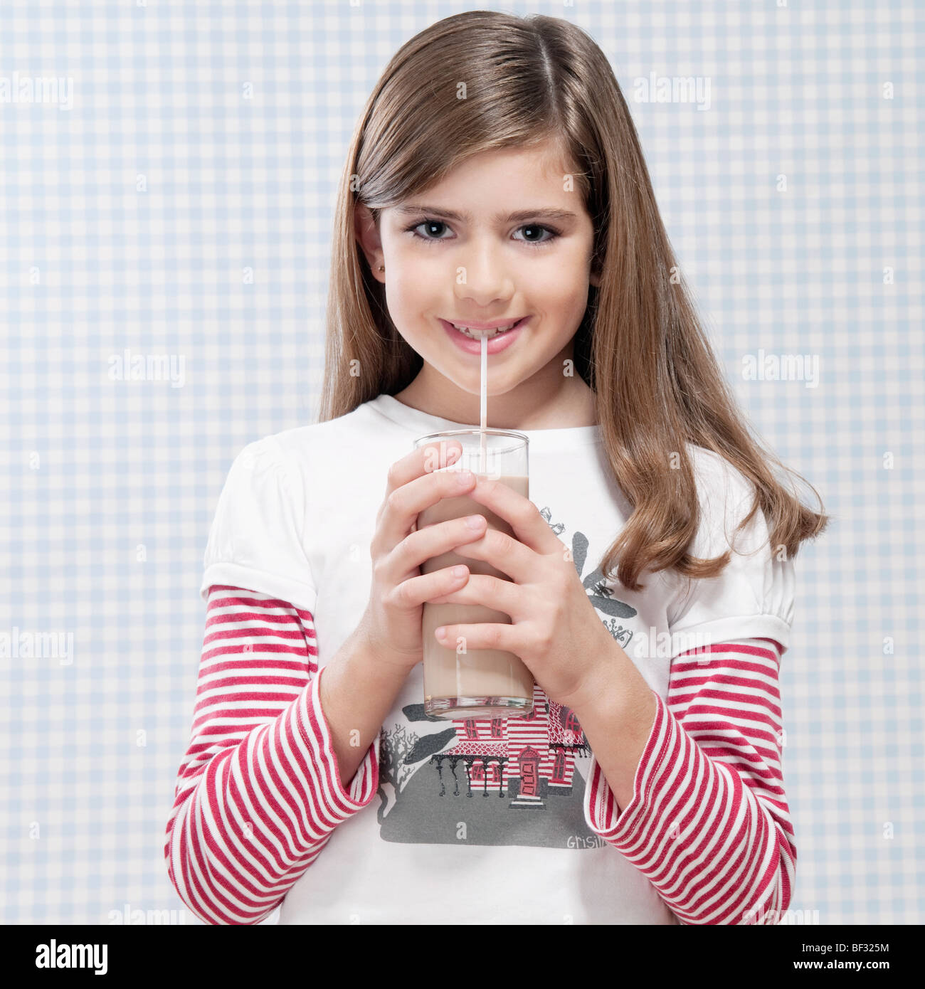 Mädchen trinken von Milch mit einem Strohhalm Stockfoto