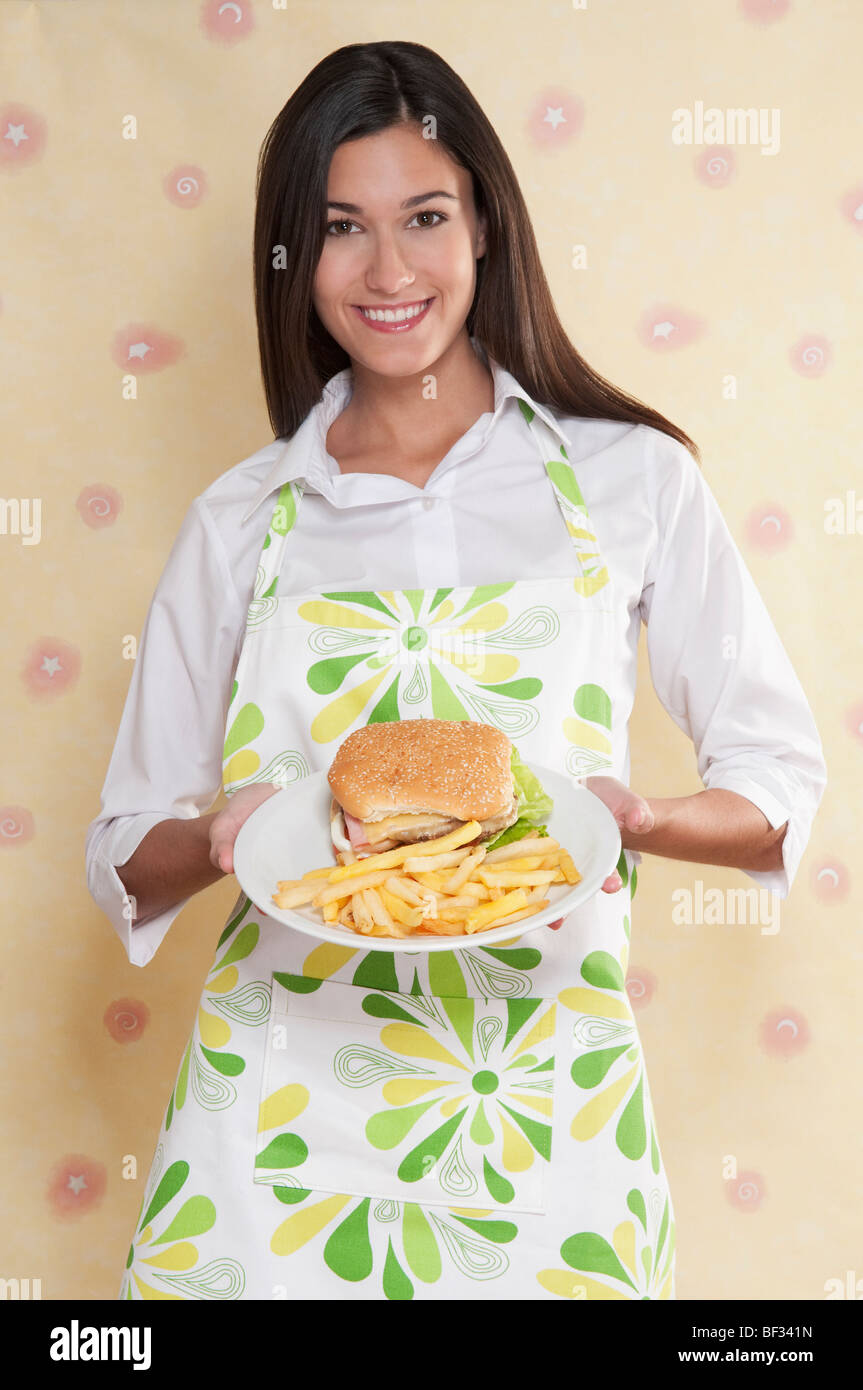 Porträt einer Frau mit einer Platte von Burger und Pommes frites Stockfoto