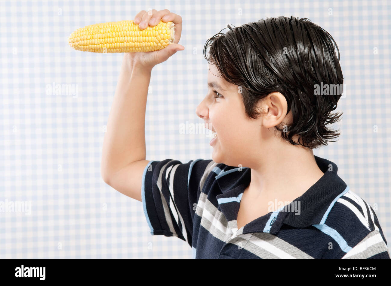 Junge hält einen Maiskolben Stockfoto